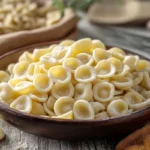 Handmade orecchiette pasta with fresh ingredients, showcasing its unique ear-like shape.